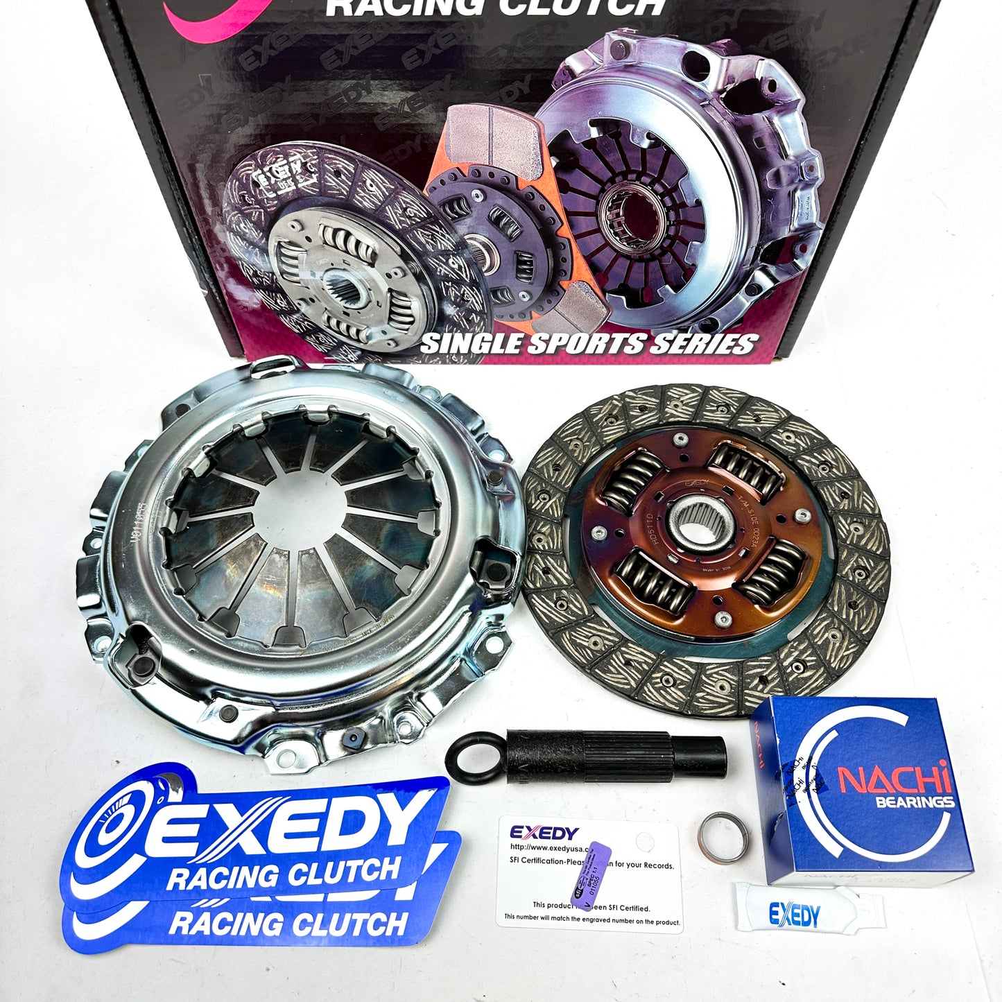 Exedy racing clutch kit components laid out next to their packaging which has 'Single Sports Series Racing Clutch' text and images.
