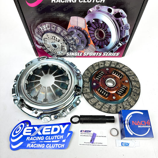 Exedy racing clutch kit components laid out next to their packaging which has 'Single Sports Series Racing Clutch' text and images.